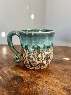 a green cup sitting on top of a wooden table