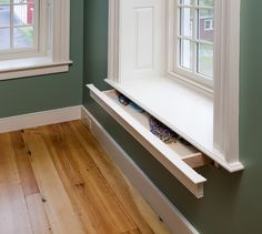 an empty window sill in the corner of a room with green walls and wood flooring