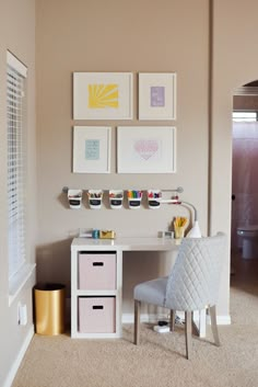 a white desk and chair in a room with pictures on the wall above it, along with other items