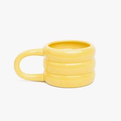 a yellow coffee mug sitting on top of a white table