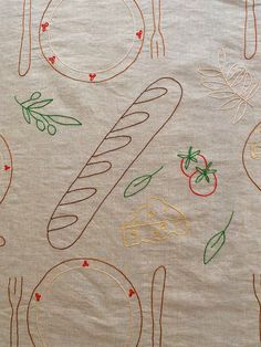 a table cloth with various hand drawn food items and utensils on the surface