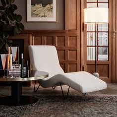 a chair and table in a room with wood paneling on the wall behind it