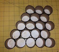 several chocolate cupcakes with white frosting arranged on a cutting board next to a ruler