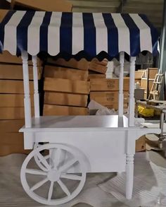 a white cart with blue and white striped awning