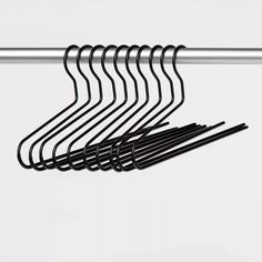 a bunch of black clothes hangers on a white wall