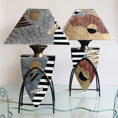 three decorative lamps sitting on top of a glass table