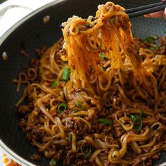 someone is eating noodles with chopsticks in a bowl