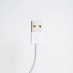 an iphone charger plugged in to a white cord with two gold - plated connectors