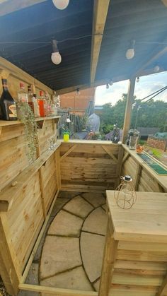 an outdoor bar with wooden walls and stone flooring, built into the side of a building