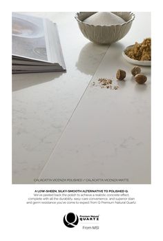 a white counter top with nuts next to it and a book on the table behind it