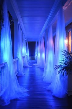 an outdoor walkway with white drapes and blue lights