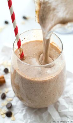 a glass filled with some kind of smoothie on top of a white tablecloth