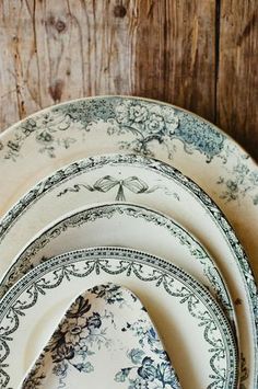 a stack of plates sitting on top of a wooden table