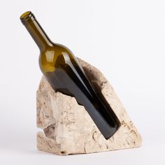 a wine bottle sitting on top of a rock