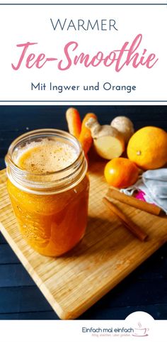 a jar filled with liquid sitting on top of a wooden cutting board next to oranges