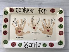 two handprinted christmas cookies for santa on a plate