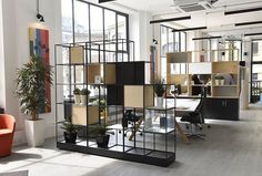 an office with lots of shelves and plants on the desks in front of them