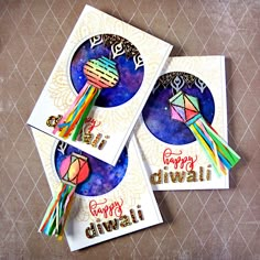 two cards with colorful designs on them sitting next to each other, and the words happy diwali written in different languages