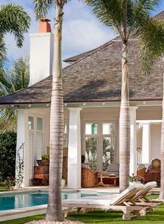 a house with a pool in front of it and a palm tree next to it