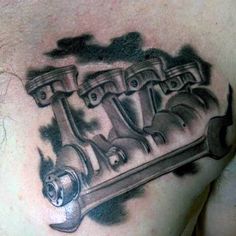 a chest tattoo with an engine on it