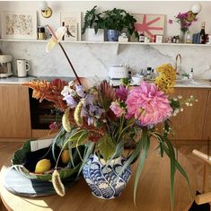 a vase filled with flowers sitting on top of a wooden table