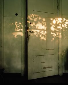 an open door with the light reflecting off it's side and shadows on the wall