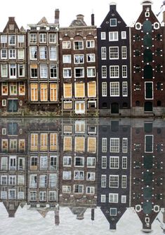 several buildings are reflected in the water