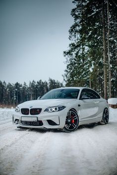 a white car driving down a snow covered road