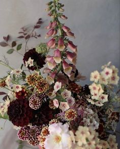 a vase filled with lots of flowers on top of a table