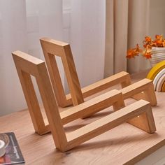 two wooden chairs sitting on top of a table next to a vase with flowers in it