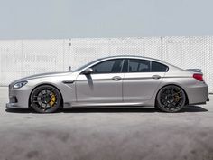 a silver car parked in front of a white wall