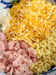 pasta, ham and cheese are mixed together in a bowl