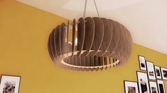 a circular light fixture hanging from the ceiling in a room with pictures on the wall