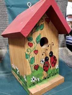 a wooden birdhouse with ladybugs painted on it