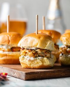 small sandwiches with toothpicks in them sitting on a cutting board