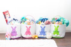 four easter baskets filled with candy, candies and stuffed animals sitting on the floor