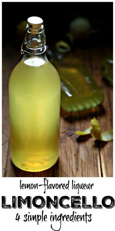 a bottle of lemon - flavored liquor sitting on top of a wooden table next to leaves