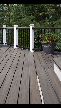 a wooden deck with white pillars and black railing