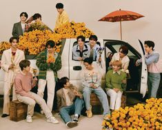 a group of young men sitting on the back of a truck with flowers in front of them