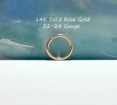 a gold ring sitting on top of a white table next to a blue and green background