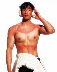 a man with no shirt talking on a cell phone and holding a towel around his waist