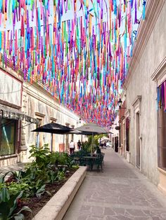 colorful streamers hang from the ceiling above an outdoor cafe