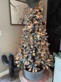 a small christmas tree in a pot with snow flakes on the bottom and lights around it