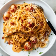 a white plate topped with pasta covered in sauce