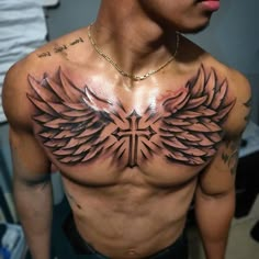 a man with tattoos on his chest and wings