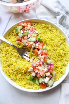 a white bowl filled with rice and veggies