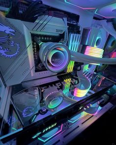 the inside of a computer case is lit up with colorful lights and gadgets