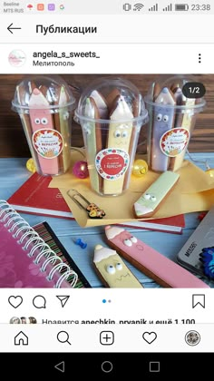 an image of some food in plastic containers on top of a wooden table with notebooks and pens