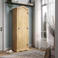 a tall wooden cabinet sitting in front of a window next to a potted plant