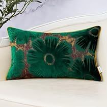 a green pillow sitting on top of a white couch next to a potted plant